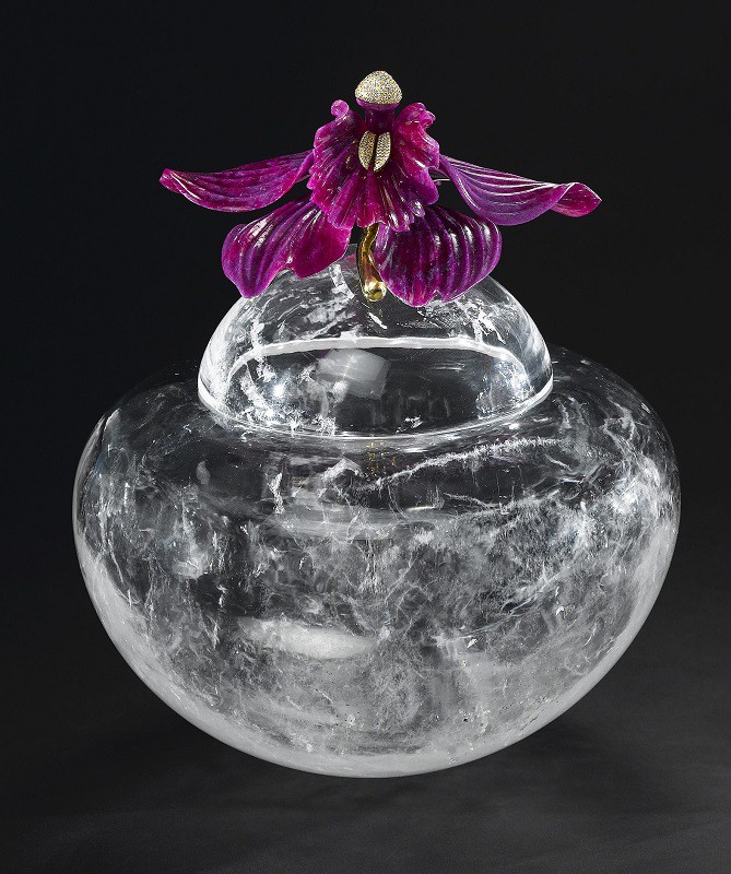 Eine bauchige Bergkristall Vase mit Bergkristall Deckel. Auf diesem Deckel ist eine gravierte dunkelrote Rubin Orchidee, mit Staubgefäßen aus Gelbgold mit Brillanten.